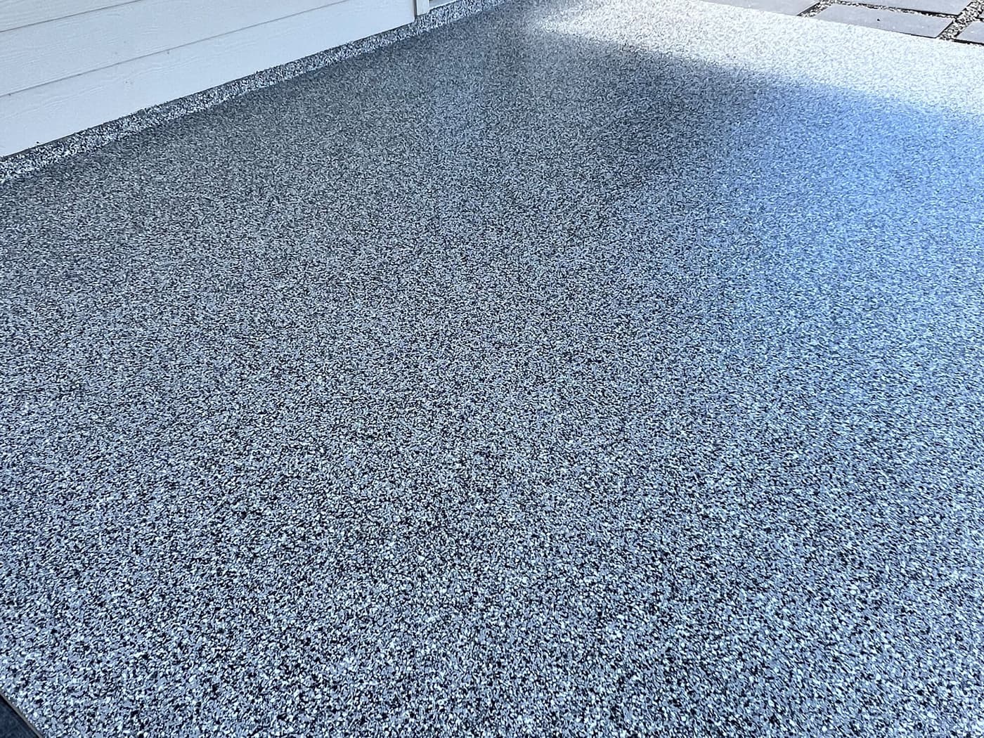 Completed gray textured coating across a covered exterior walkway
