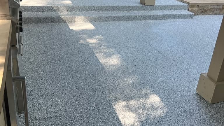 Completed gray textured exterior coating connecting a landing and steps