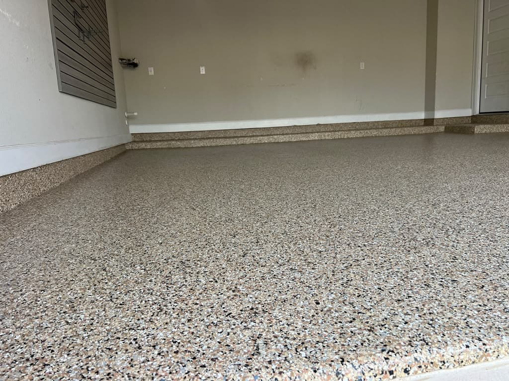 Completed residential garage with a warm neutral flake floor