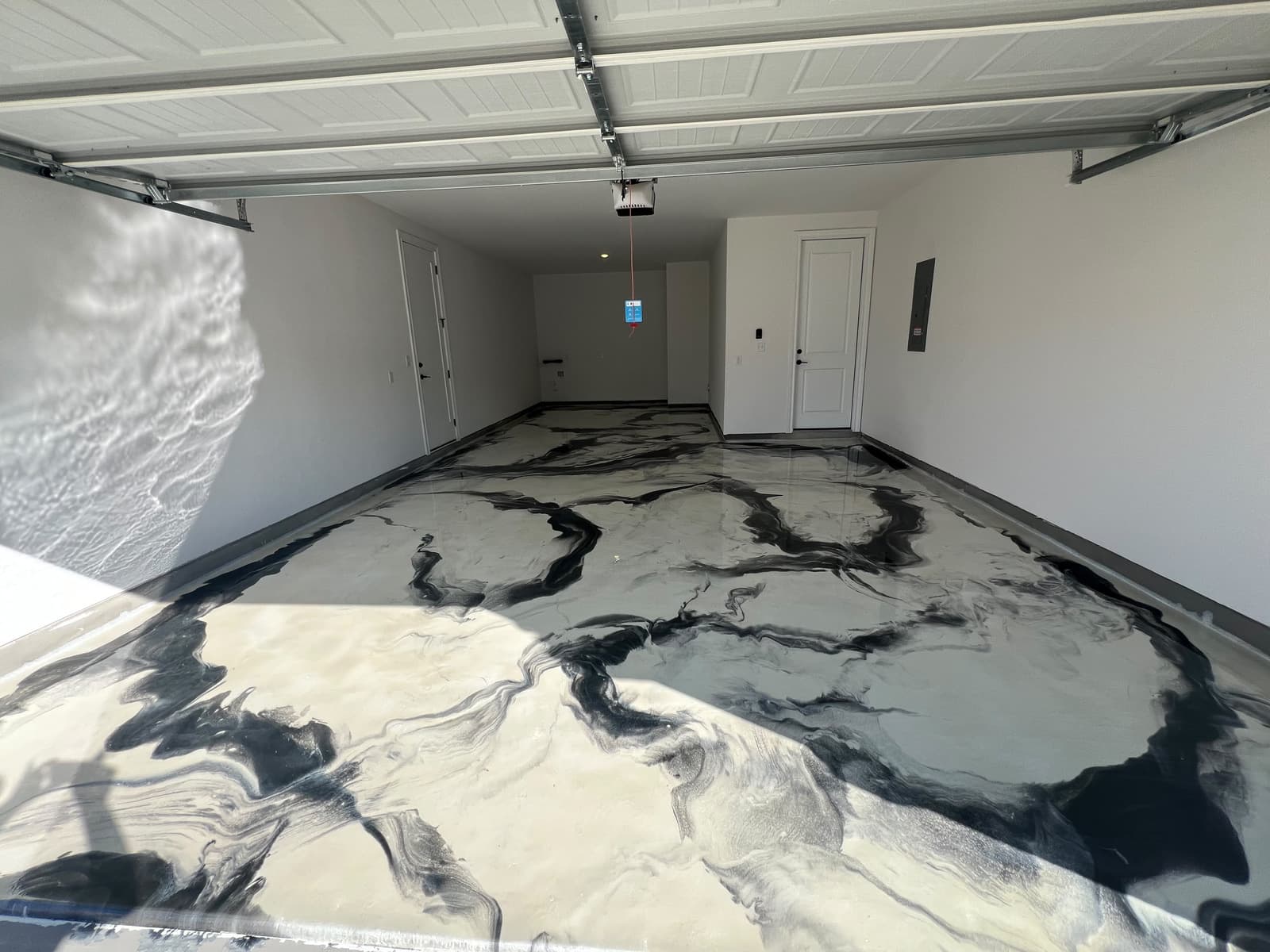 White and black metallic floor spanning a completed garage