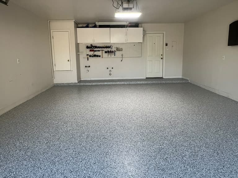 Completed gray flake floor across a residential garage bay