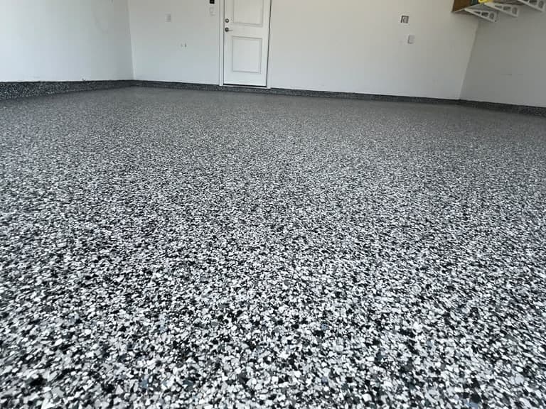 Close garage view showing a completed black, white, and gray flake floor