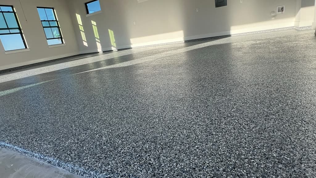 Completed gray flake epoxy floor in a bright residential garage
