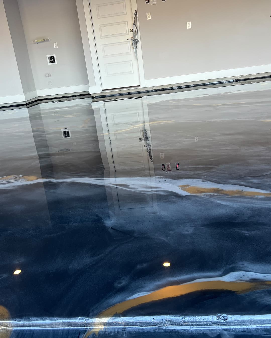 Completed dark blue, gray, and gold Metallic epoxy floor with reflective movement