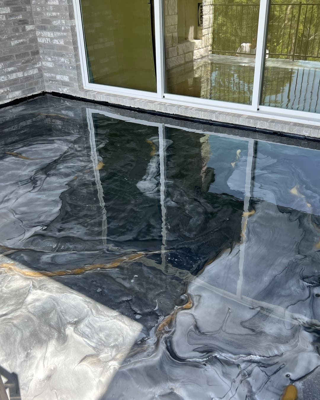 Black, silver, and gold metallic floor across a finished covered exterior