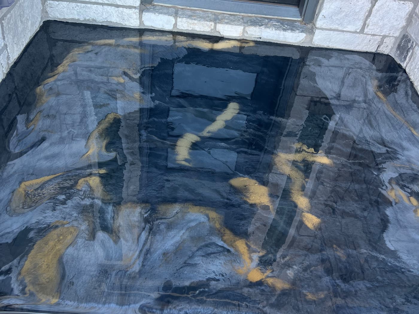 Completed black, blue, and gold Metallic epoxy floor at an entry