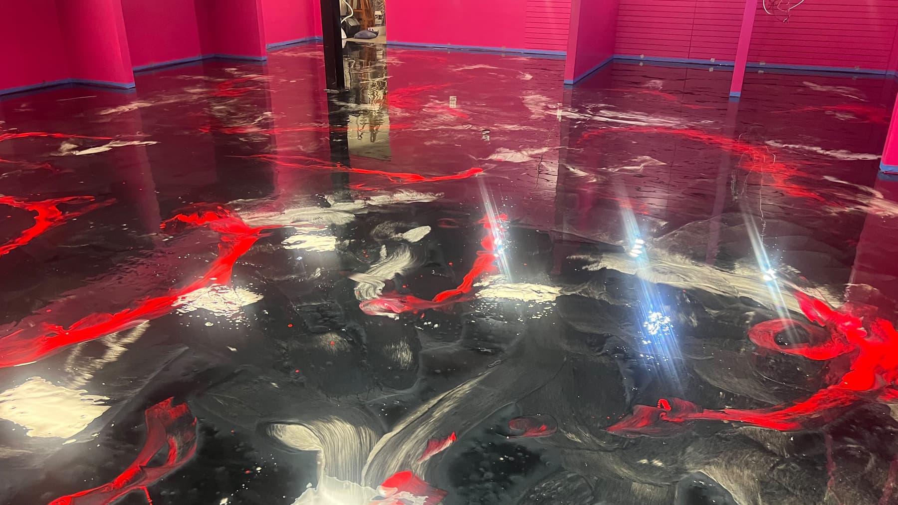 Completed red, black, and silver Metallic epoxy floor across a statement interior