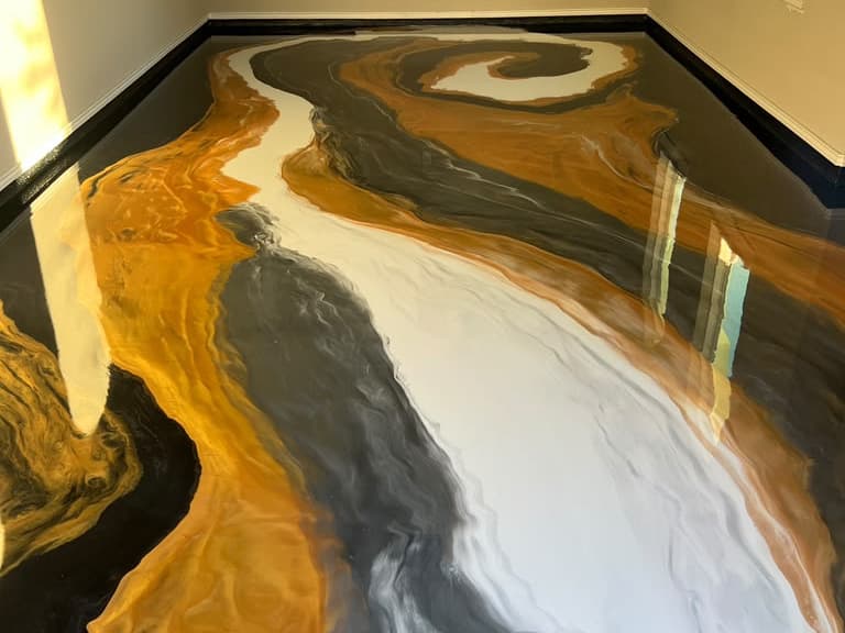 Completed gold, white, and charcoal Metallic epoxy floor with flowing movement