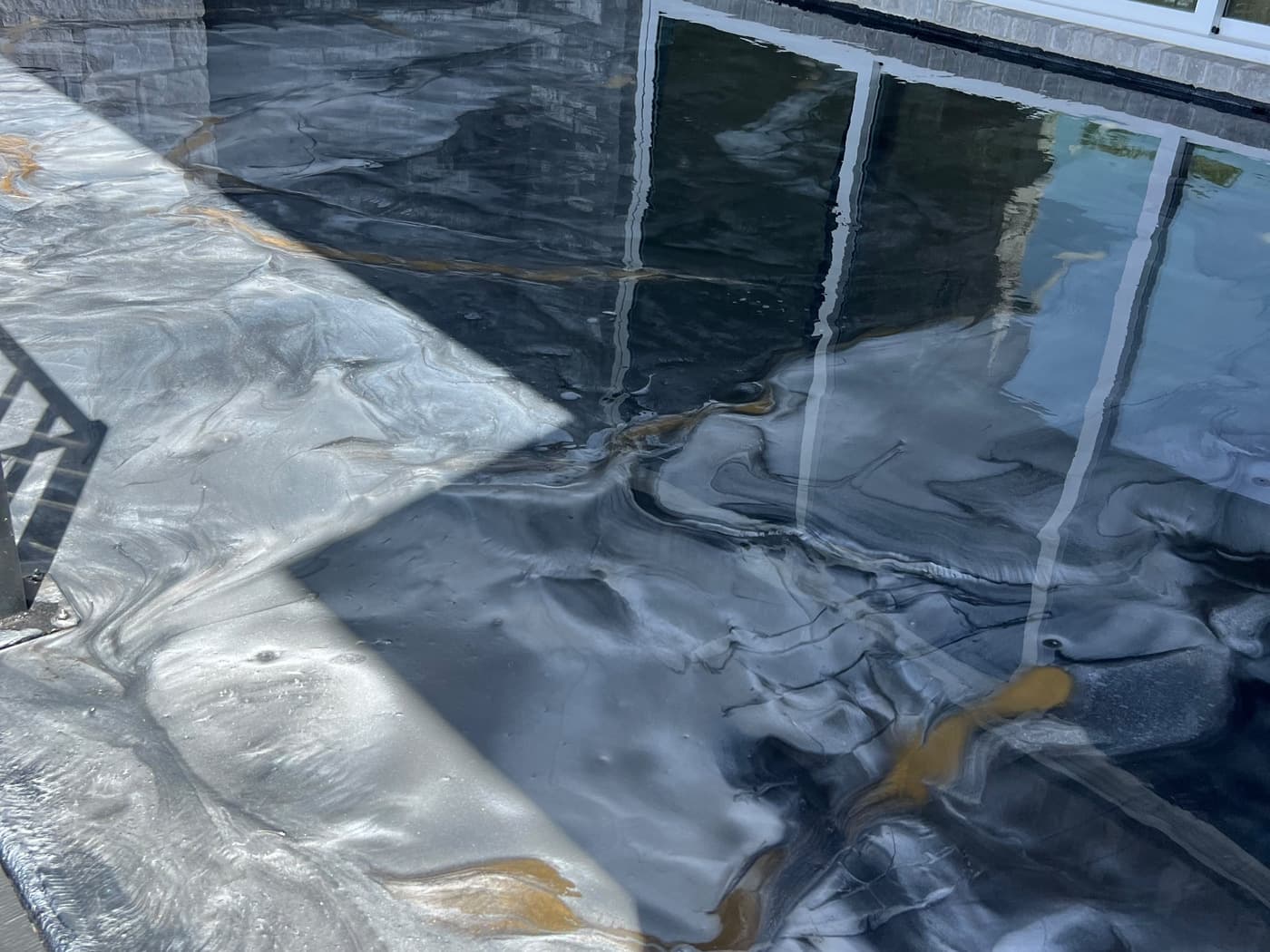 Completed charcoal, silver, and gold metallic coating beside a residential exterior